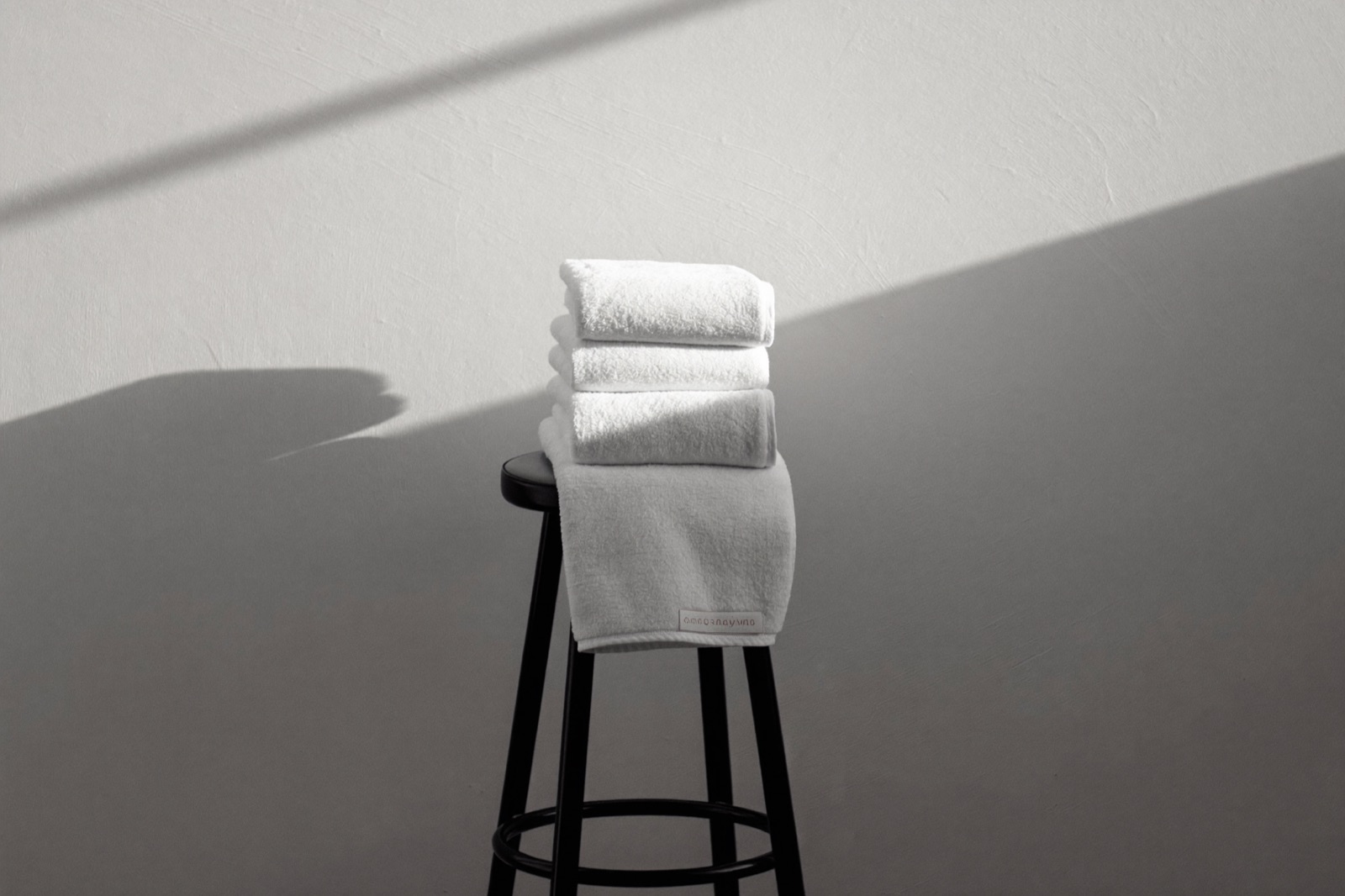 Gefaltete Handtücher auf einem Hocker im Tageslicht des Studios